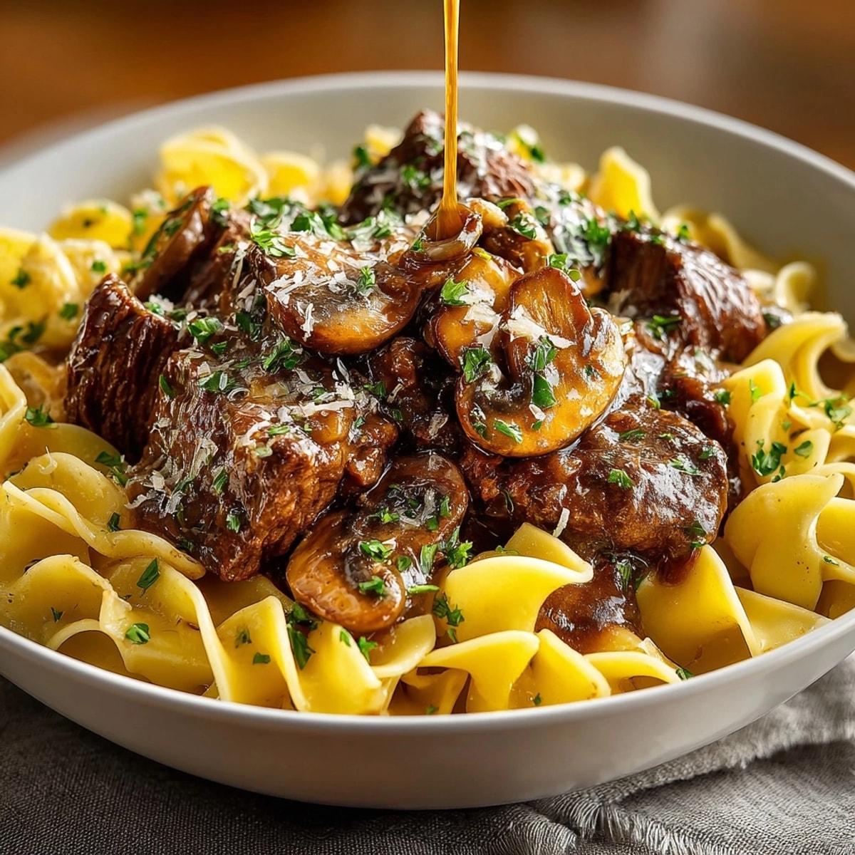 Slow cooker beef and mushroom gravy simmers, ready to serve over egg noodles.