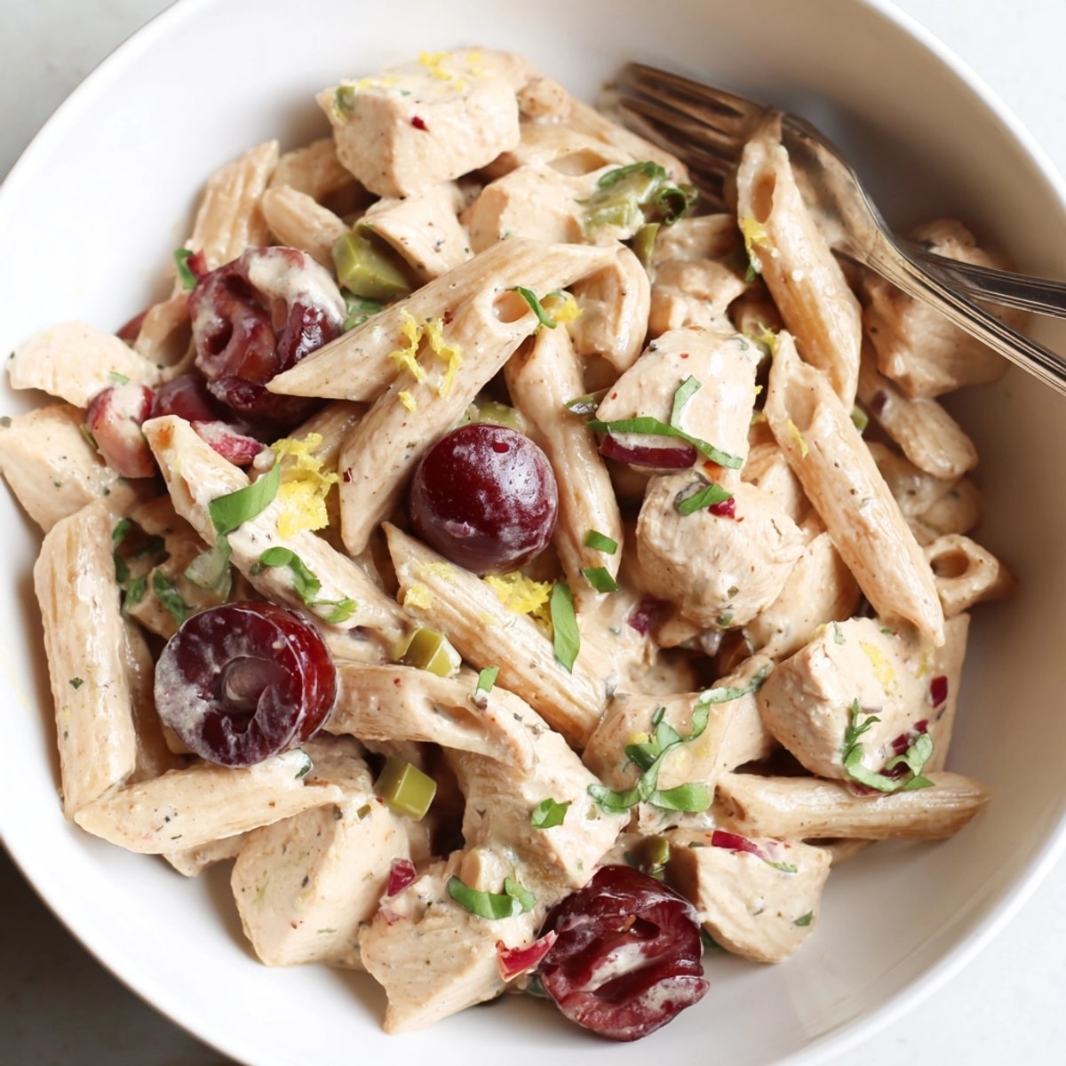 Top-down tempting view of creamy Cherry Jalapeño Chicken Pasta, garnished with fresh basil.