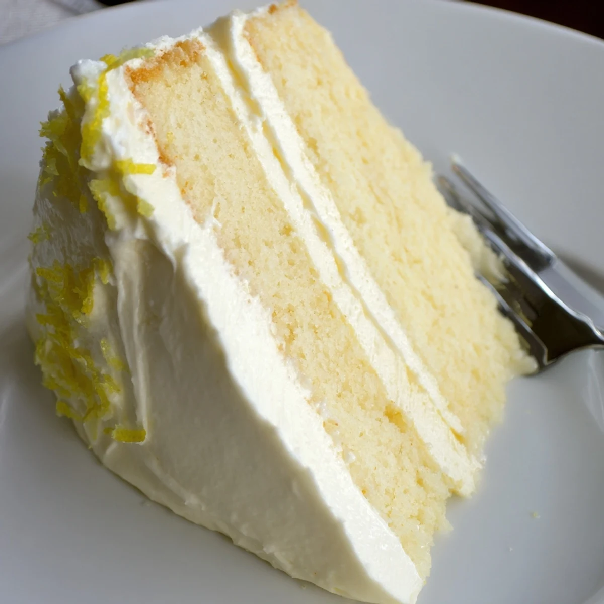 Lemon Cheesecake Cake layered with creamy frosting and vibrant lemon zest for a delightful dessert.  