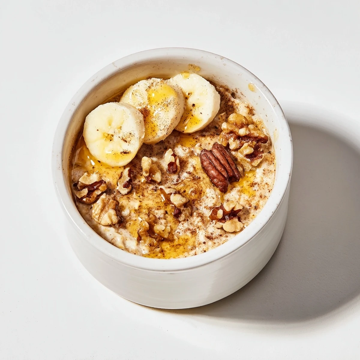 Steaming baked oats ramekins with banana and honey, a warm, golden breakfast treat.