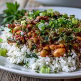 Vegetarian Hoppin John served with a lemon wedge and vibrant green onions garnish.