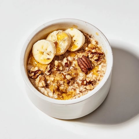 Steaming baked oats ramekins with banana and honey, a warm, golden breakfast treat.
