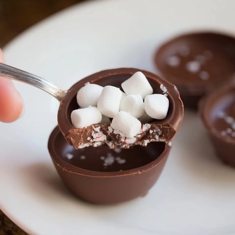 Warm, rich Budget-Friendly Hot Cocoa Bomb Cups, filled with marshmallows, ready to melt into warm milk.