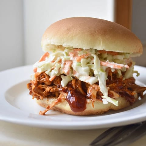 Delicious pulled BBQ chicken sliders garnished with zesty coleslaw for added crunch.  