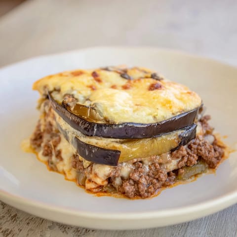 A warm, hearty slice of moussaka with a flavorful beef filling, ready to serve to hungry guests.