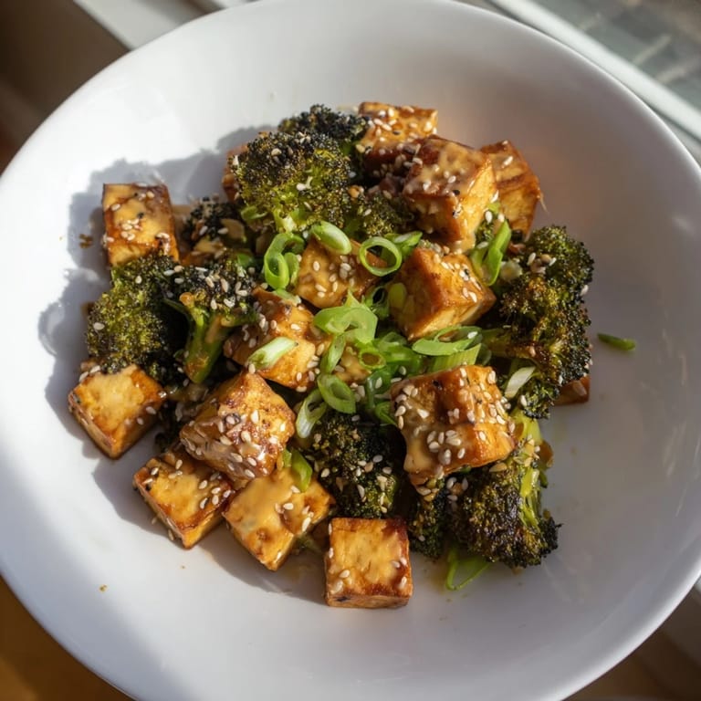 Creamy, cheesy sauce coats the crispy Cheesy Baked Tofu and Broccoli, melding with roasted broccoli florets.