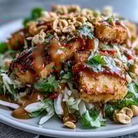 Vibrant Thai Mango Salad loaded with crispy tofu and creamy peanut sauce.